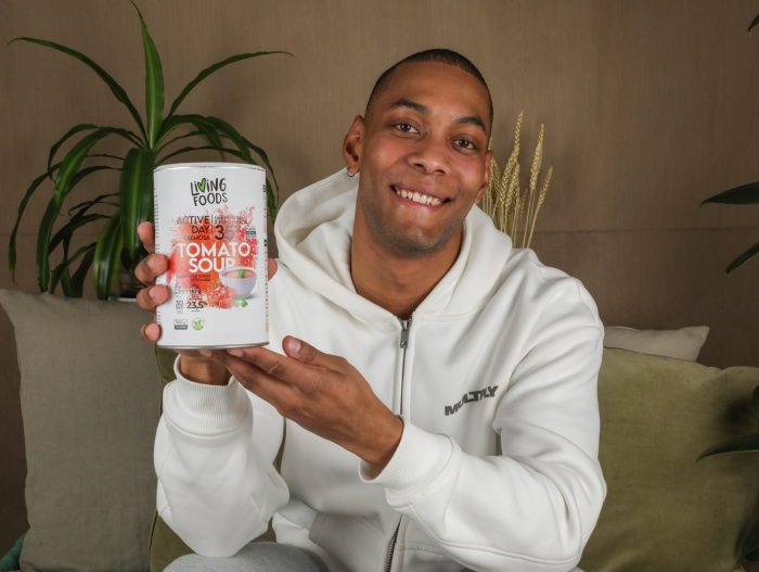 Persona con un bote de superalimentos germinados en la mano, presentandolo.