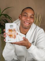 Persona con un bote de superalimentos germinados en la mano, presentandolo.